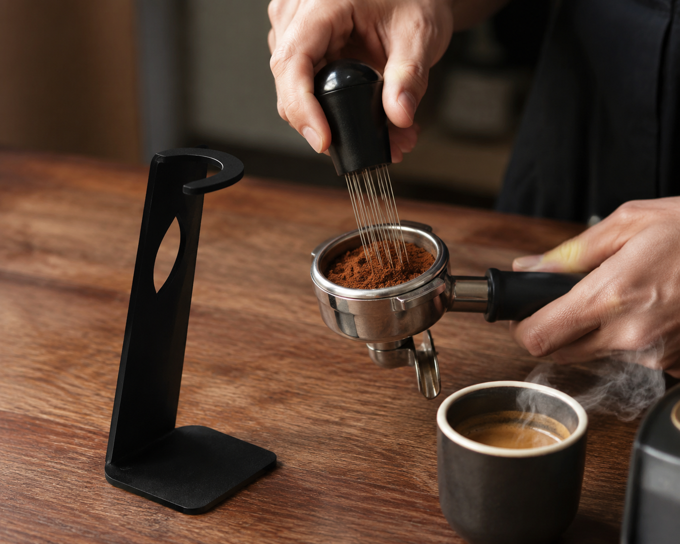 WDT stirrer tool in use distributing coffee grounds in basket